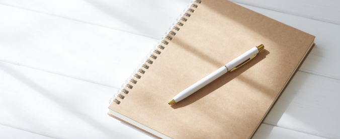 ノートとペンが机に置かれている